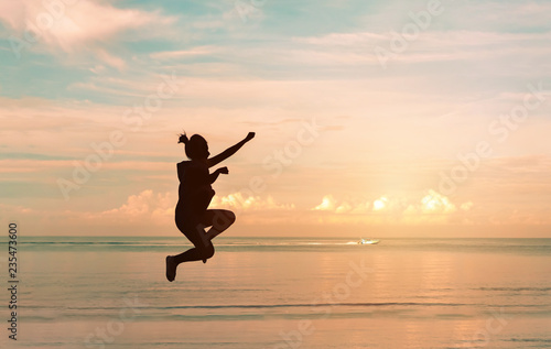 Young asian woman enjoy jumping on the beach at sunset time