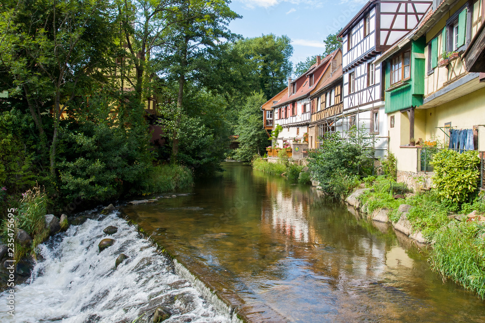 French traditional half-timbered houses near La Weiss river in Kayserberg village in Alsace, France