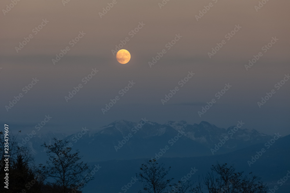 Full moon over the mountains, after an autumn sunset Full moon over the mountains, after an autumn sunset