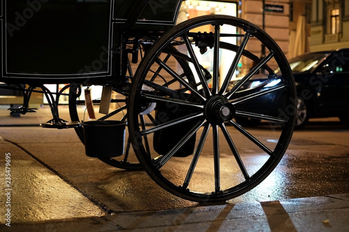 Fiacr wheel opposite the light from the shops and car headlights in Vienna. photo