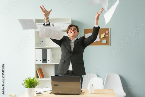 Business people, joke and fun concept - happy funny businessman throwing papers in office