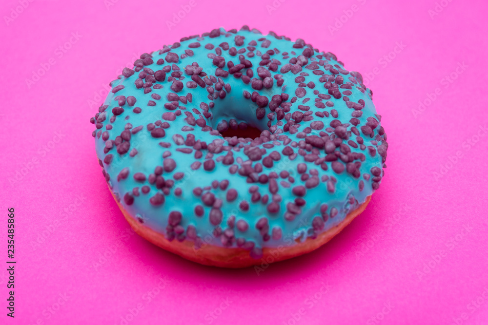 blue donut with sprinkles isolated on pink background blue donut with sprinkles isolated on pink background