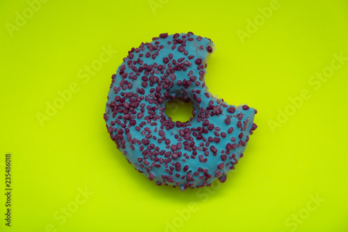 blue stuffed donut with colorful sprinkles isolated on green background. Top view.