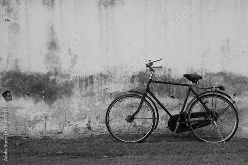 Vintage Bicycle against Old Plastered Wall Background in Black & White
