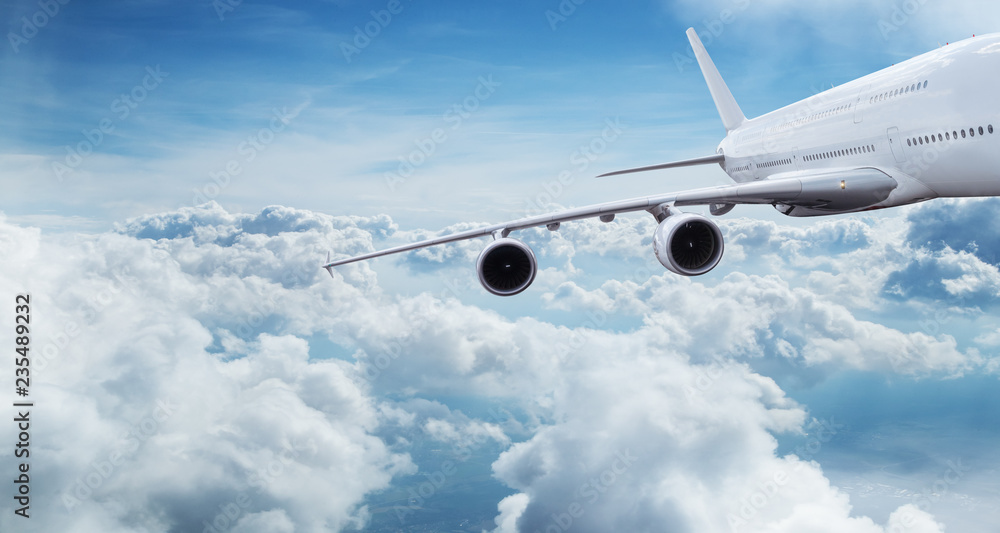 Obraz premium Duży samolot latający nad chmurami dramatycznymi.