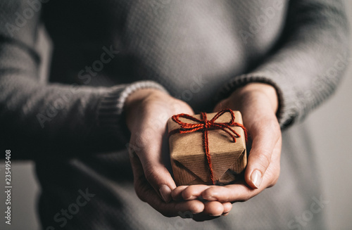 Foto Hands give gift with red bow for Christmas or Thanksgiving Day