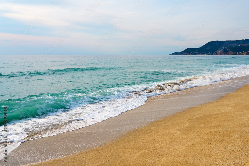 Waves with foam hitting sand on Kleopatra beach in Alanya, Turkey on a sunset against a cloudy sky. Waves with foam hitting sand on Kleopatra beach in Alanya, Turkey on a sunset against a cloudy sky.