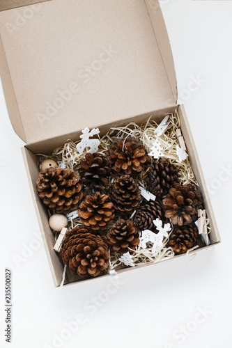 Set of pinecones in craft box on wood shavings. © sweetlaniko