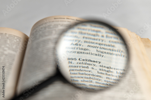 Celibacy word magnified on old book photo