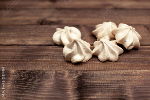 Mini meringue on wooden background with space for text.