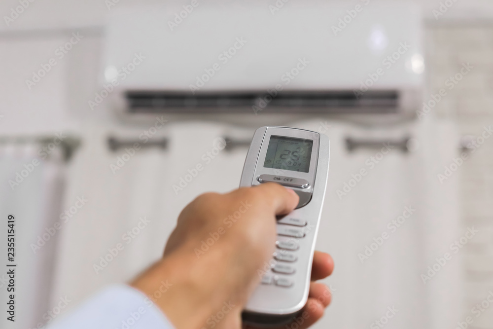 hand holds a remote control of air conditioner