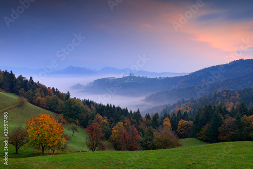 Landscape in Slovenia, nature in Europe. Foggy Triglav Alps with forest, travel in Slovenia. Beautiful sunrise with blue sky, green nature.