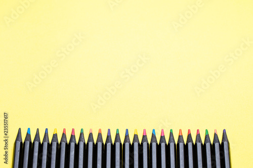 Color pencils on a yellow background close-up