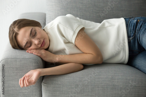 Foto Attractive calm woman sleeping on comfortable soft couch in living room, beautif