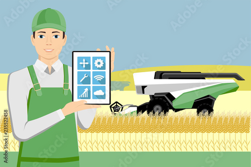 Farmer controls an autonomous combine harvester with tablet computer. Internet of things in agriculture
