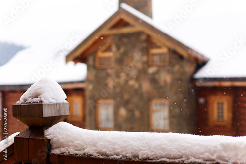 Wallpaper Mural Snow-covered surface for product placement. Blurred house made of wood and stone on background. Snowfall on winter day. Christmas background with wooden cottage or chalet at ski resort. Copyspace. Torontodigital.ca