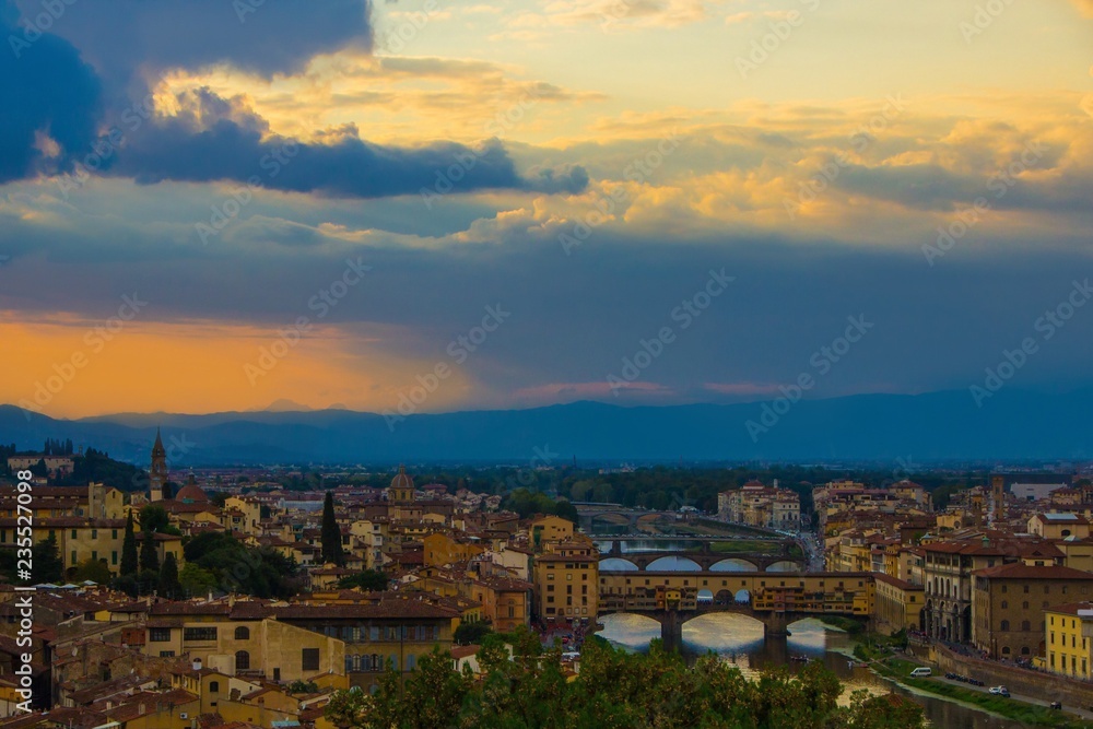 Sunset over the beautiful city of Florence. View of Ponte Vecchio and Arno river as seen from the Michelangelo Hill. Florence, Italy.