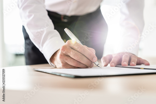 Unrecognizable businessman leaning in to sign a contract