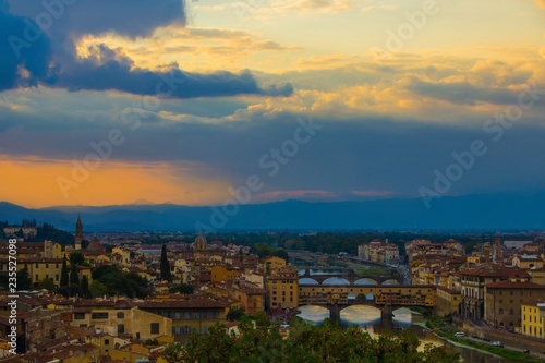 Sunset over the beautiful city of Florence. View of Ponte Vecchio and Arno river as seen from the Michelangelo Hill. Florence, Italy.