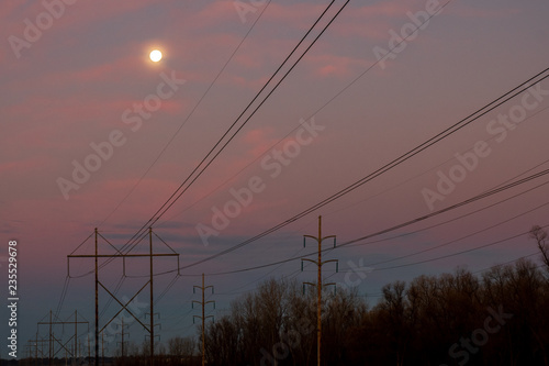 Powerlines at dawn with moon in the sky