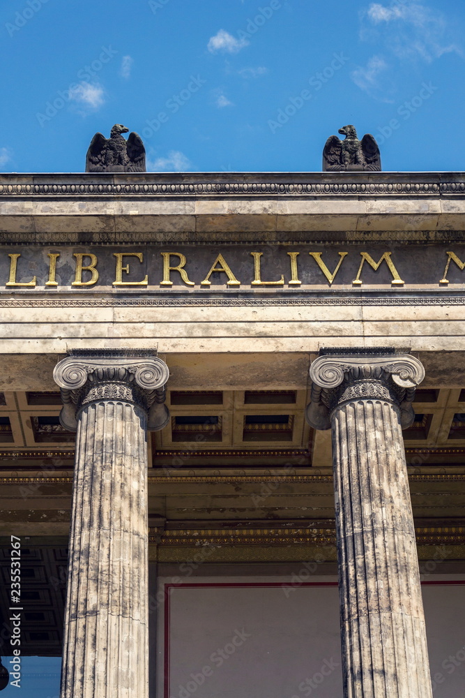 Eagle sculptures on the roof of Altes Museum . Old Museum in Berlin, Germany, latin inscription on portico means liberal