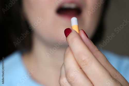 Woman takes a pill  close-up. Girl putting capsule in mouth  sick female taking medicines  antidepressant  painkiller  antibiotic or contraceptive