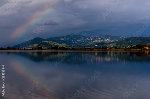 The rainbow is reflected in the waters of Lake Massaciuccoli, Lucca, Tuscany, Italy © Marco Taliani