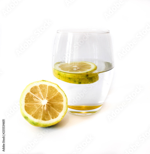 glass of water and lemon on white background.