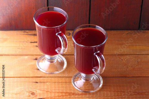 Mulled wine on wooden boards. Christmas mulled wine in glass cups. Alcoholic drink of wine and fruit. Festive drink on wooden boards. Copy space