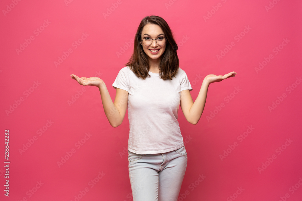 Photo of happy young woman standing isolated over pink background. Looking camera showing copyspace pointing. Photo of happy young woman standing isolated over pink background. Looking camera showing copyspace pointing.