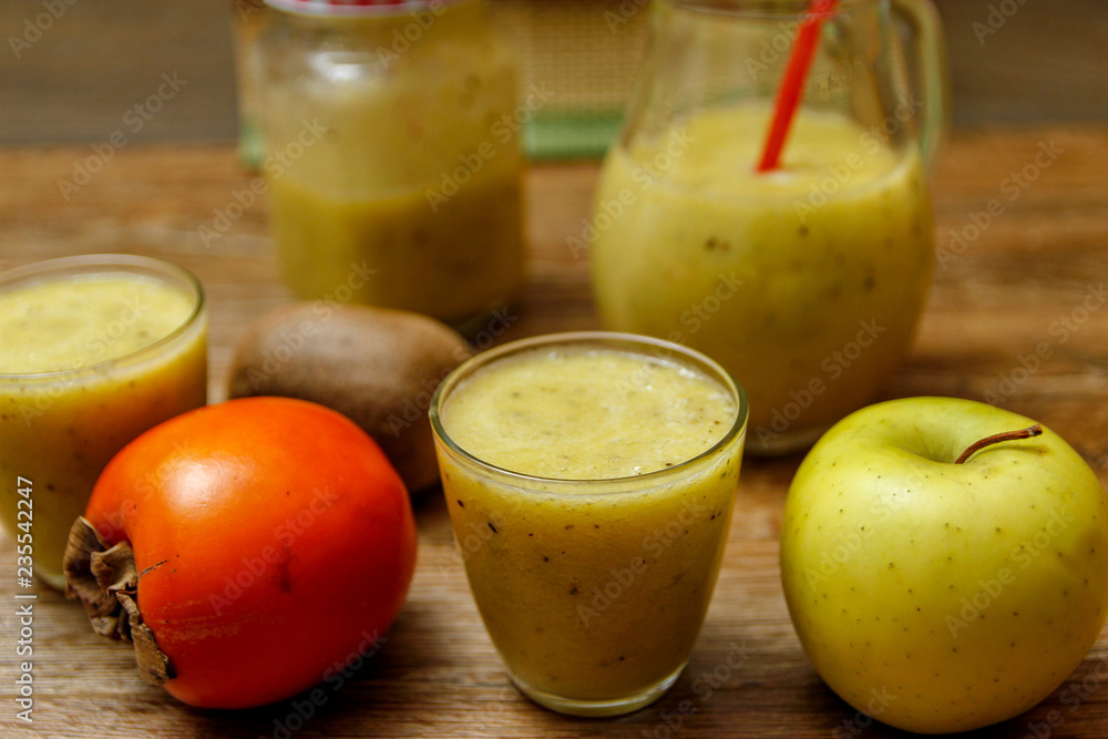 Freshly blended fruit smoothie with fresh fruits on wooden table with raw fruits Freshly blended fruit smoothie with fresh fruits on wooden table with raw fruits