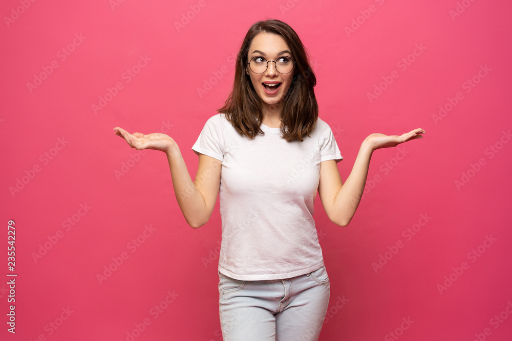 Photo of happy young woman standing isolated over pink background. Looking camera showing copyspace pointing. Photo of happy young woman standing isolated over pink background. Looking camera showing copyspace pointing.