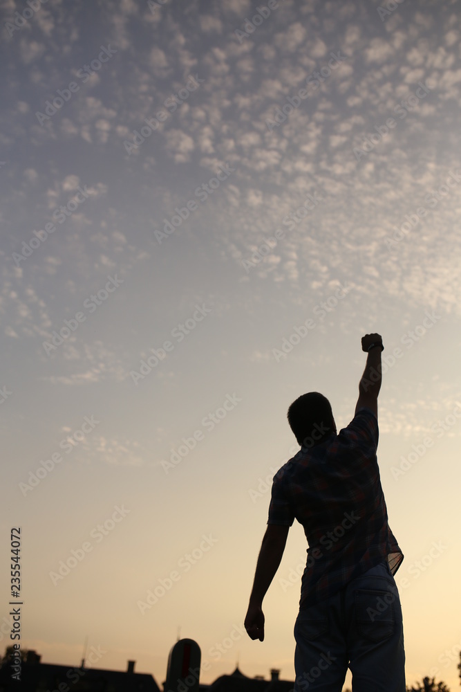 silhouette of a man with arms raised