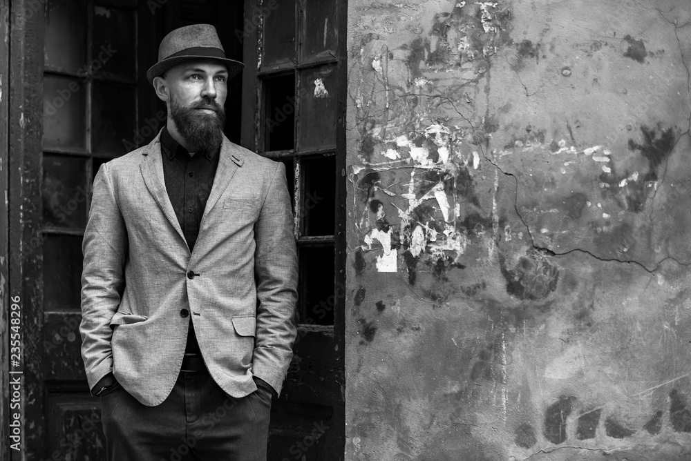 stylish man with a beard in a hat on the street