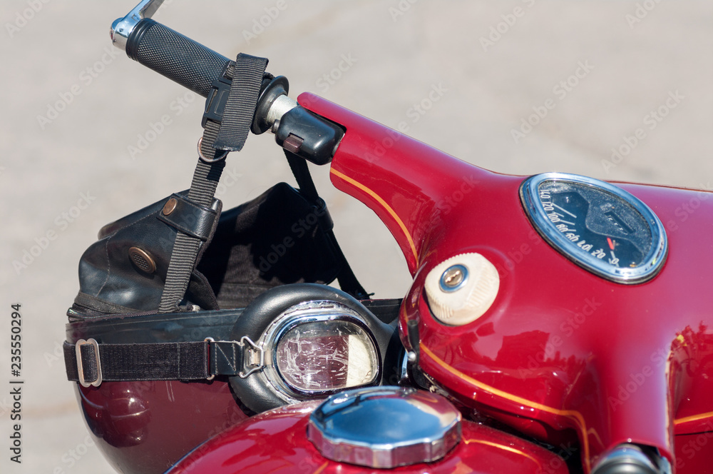old model's motorcycle, red with chrome elements, retro helmet on the steering wheel old model's motorcycle, red with chrome elements, retro helmet on the steering wheel
