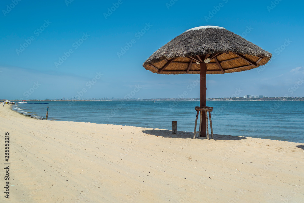 Straw parasol on tropical and paradisiac beach