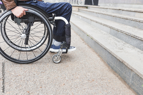 Man in wheelchair in front of stairs.