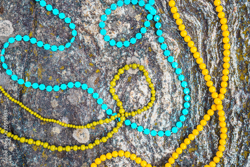 Colorful necklaces on mossy rock background