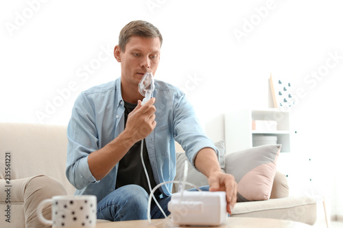 Fotografía Man using asthma machine at home. Health care