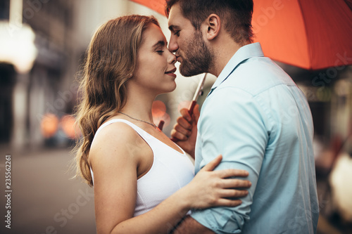 Couple standing on street embracing each other