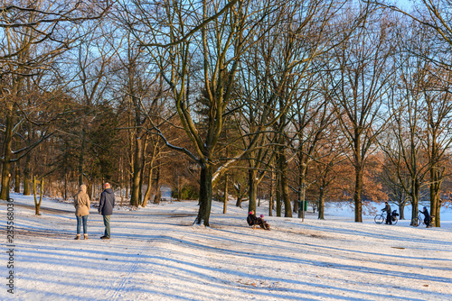 Outdoor winter scenery of family and couple enjoy snowy landscape of Volkspark Rehberge, Goethe Park and Rathenaubrunnen in Wedding district, in Berlin, Germany. 