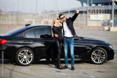 Beautiful couple is holding a key of their new car, looking at camera and smiling © Maksymiv Iurii