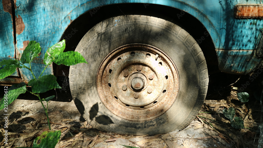old flat tyre of old blue vehicle in the abandoned place old flat tyre of old blue vehicle in the abandoned place