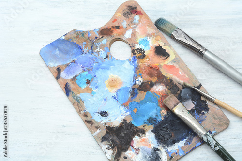 Artist's palette with colorful oil paint strokes and paintbrushes