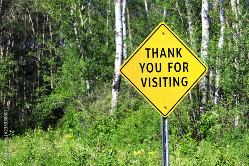 A thank you for visiting sign against a forest background