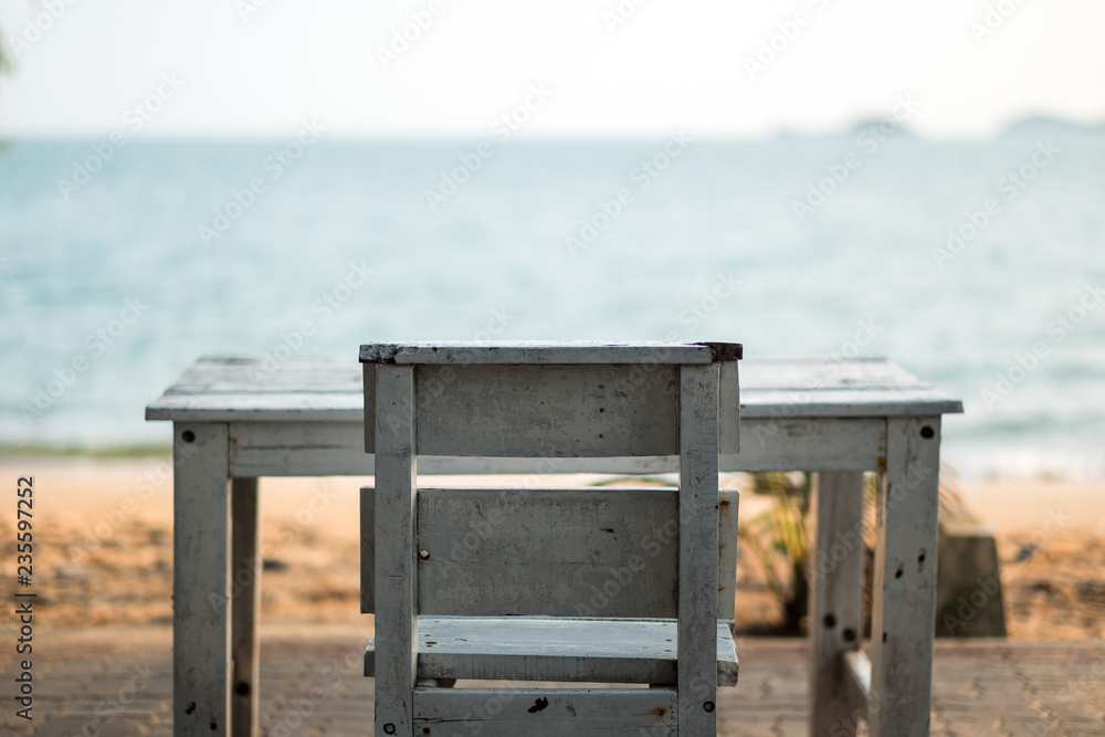 summer background old wooden table and chair on beach with sea this place peaceful