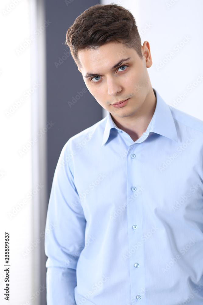 Young businessman standing straight in office. Business concept Young businessman standing straight in office. Business concept