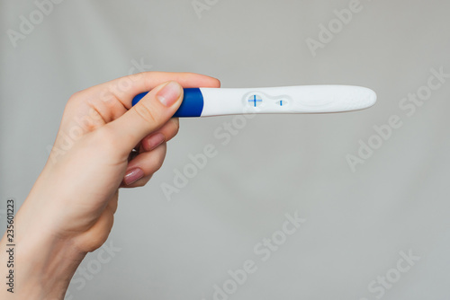 positive pregnancy test in the hands of a girl close-up