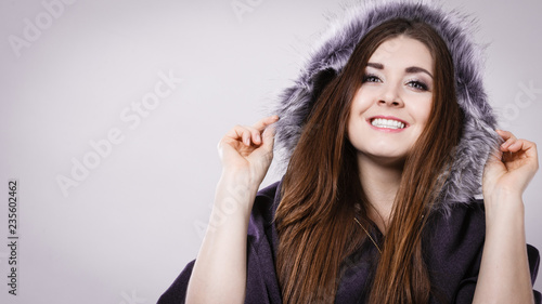 Happy woman wearing dark poncho with hood