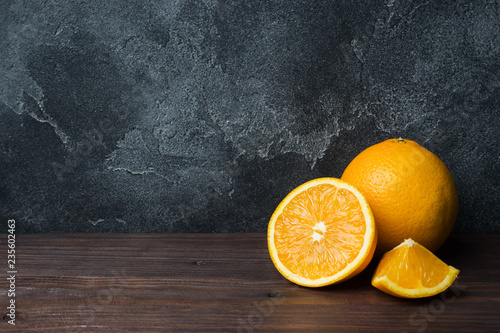 Fresh oranges on black stone background, copy space © Elenglush